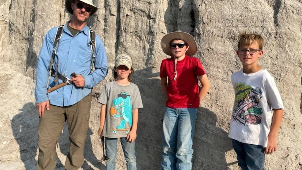 Liam (7), Jessin (10) und Kaidn (9) posieren zusammen mit dem Wissenschaftler Tyler Lyson, der das von ihnen entdeckte T-Rex-Skellet untersuchte.