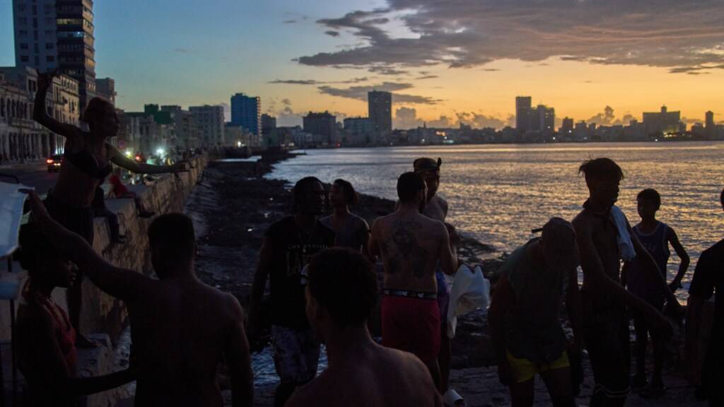 ARCHIV - Menschen beobachten den Sonnenuntergang vom Malecón aus während eines Stromausfalls in Havanna. Foto: Ramon Espinosa/AP/dpa/Archivbild