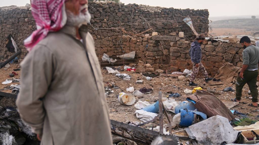 Männer begutachten die Folgen eines jordanischen Luftangriffs auf dem Land in der Provinz Daraa im Süden Syriens. Foto: Ghaith Alsayed/AP/dpa
