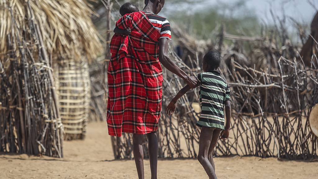 ARCHIV - Ein Vater hilft seinem unterernährten Sohn beim Gehen in der Nähe ihrer Hütte in dem Dorf Lomoputh im Norden Kenias. Foto: Brian Inganga/AP/dpa