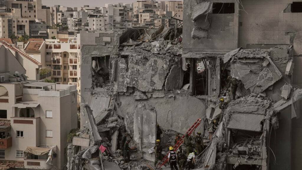Israelische Soldaten und Rettungskräfte arbeiten inmitten der Trümmer von Wohnhäusern. Foto: Leo Correa/AP/dpa
