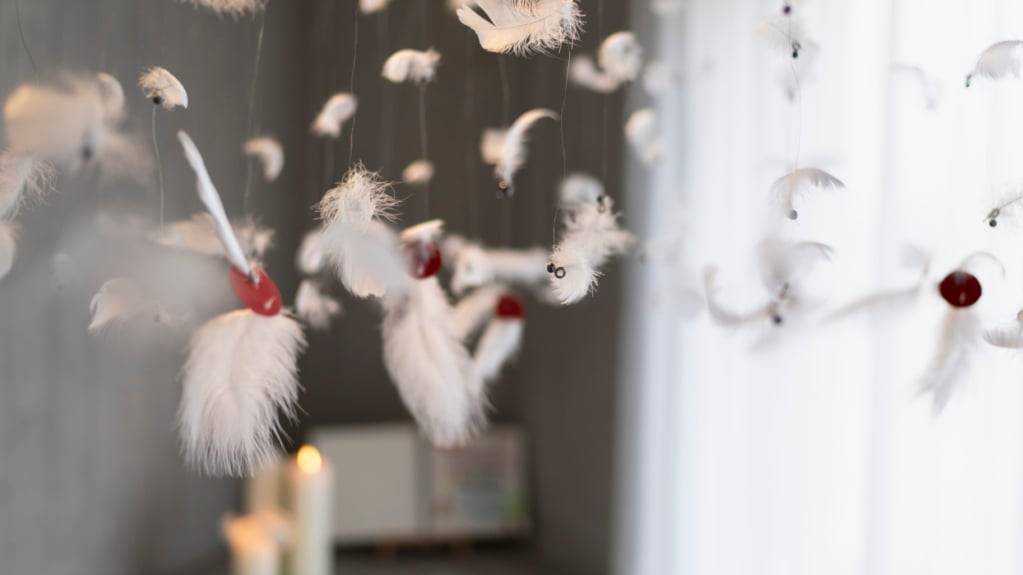 Ein Erinnerungsraum mit Kerze, Erinnerungsbuch und Mobile aus weissen Federn in einem Palliativzentrum. (Symbolbild)