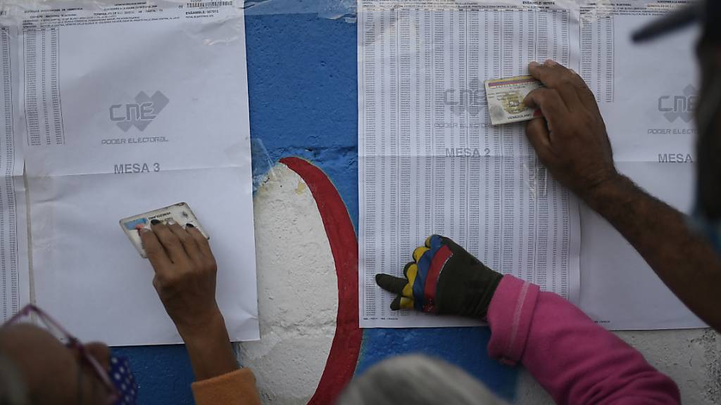 Einwohner von Caracas überprüfen auf einem Aushang, in welchem Wahllokal sie ihre Stimme abgeben müssen. Foto: Matias Delacroix/AP/dpa
