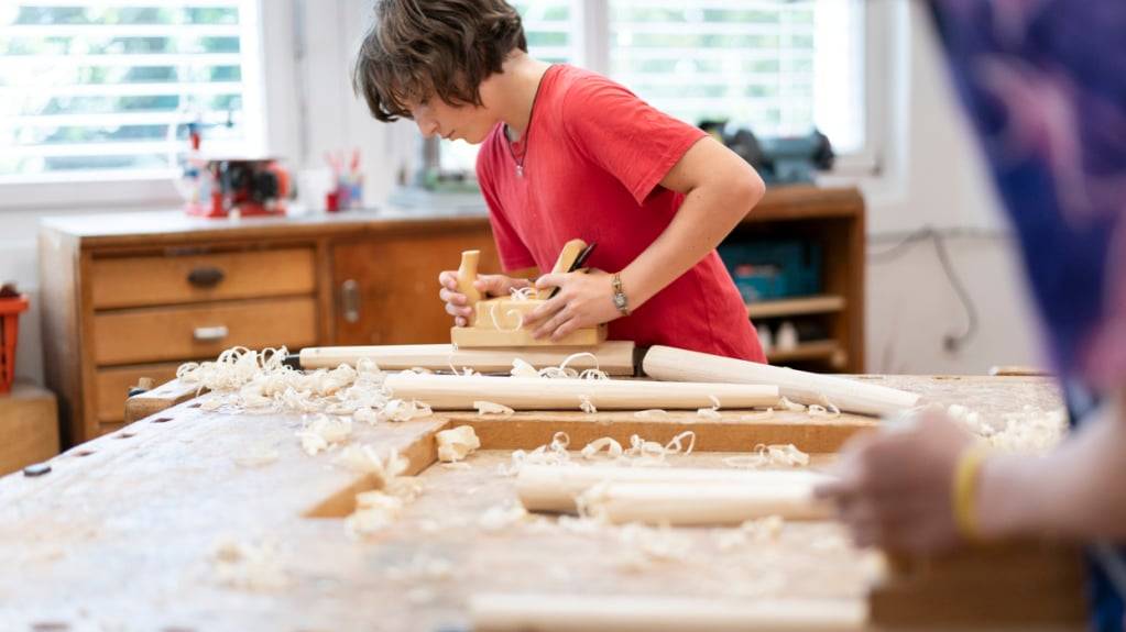 Jugendliche der 6. Klasse hobeln während des Werkunterrichts  Holz. (Archivbild)