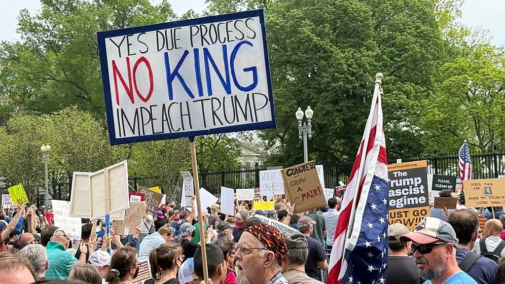 Teilnehmer einer Demonstration gegen die Politik von US-Präsident Trump stehen vor dem Zaun beim Weißen Haus. Foto: Thomas Müller/dpa