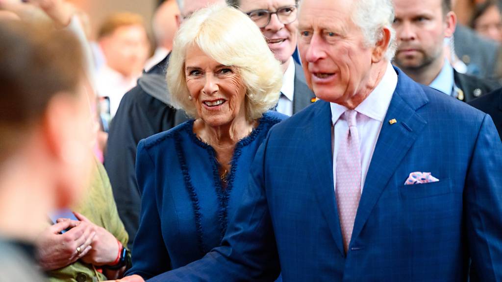 ARCHIV - König Charles III. von Großbritannien und Königin Camilla begrüßen Gäste. Foto: Jonas Walzberg/dpa