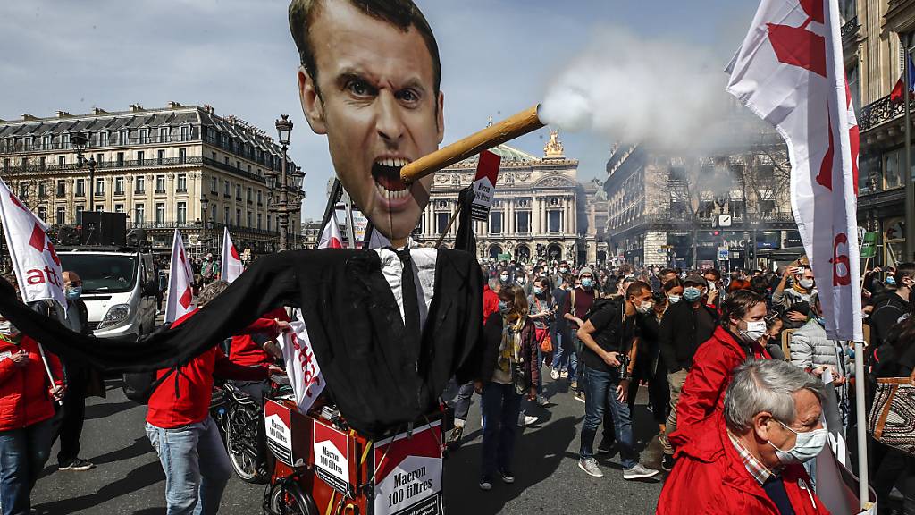 dpatopbilder - Demonstranten nehmen in Paris mit einem Plakat, das den französischen Präsidenten Macron mit einer rauchenden Zigarre darstellt, an einer Kundgebung für eine beherztere Klimapolitik teil. Foto: Michel Euler/AP/dpa