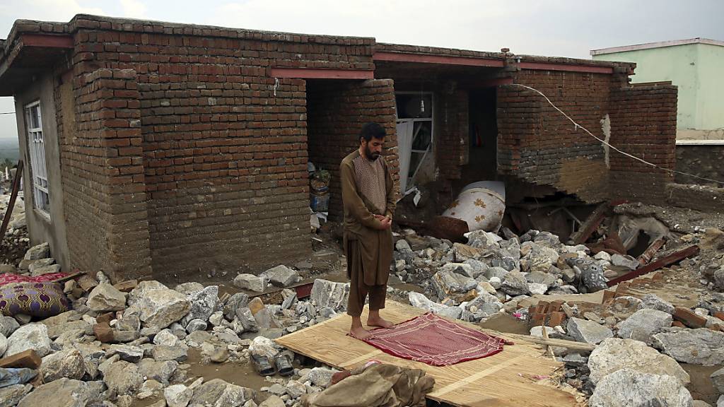 Ein Mann betet neben seinem Haus in Parwan, das von einer Schlammlawine zerstört wurde. Landesweit sind bei Sturzfluten dutzende Menschen gestorben.