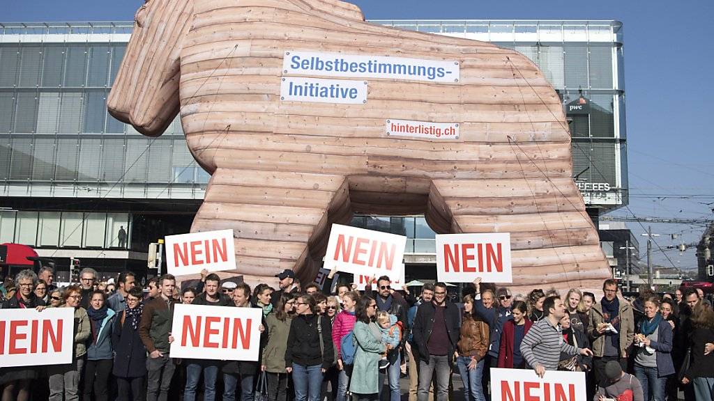 Personen demonstrieren in Bern mit einem Trojanischen Pferd gegen die Selbstbestimmungsinitiative der SVP.