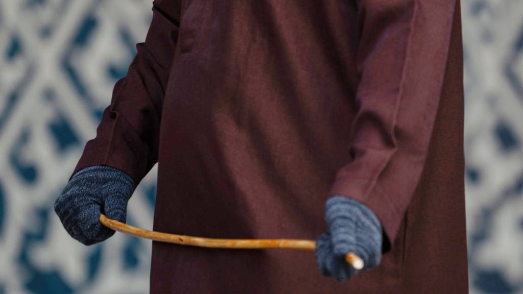 Ein Vertreter der Scharia mit einem Stock in der Hand vor der öffentlichen Auspeitschung. Foto: Reza Saifullah/AP/dpa