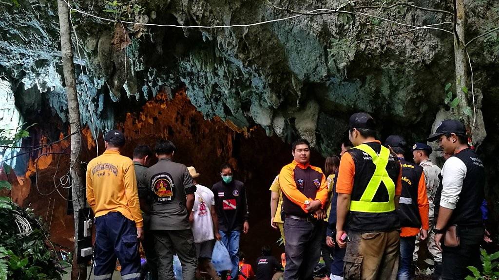 Retter und Parkverantwortliche am Eingang der Höhle in Thailand, in der die Junioren-Mannschaft und ihr Trainer festsitzen.
