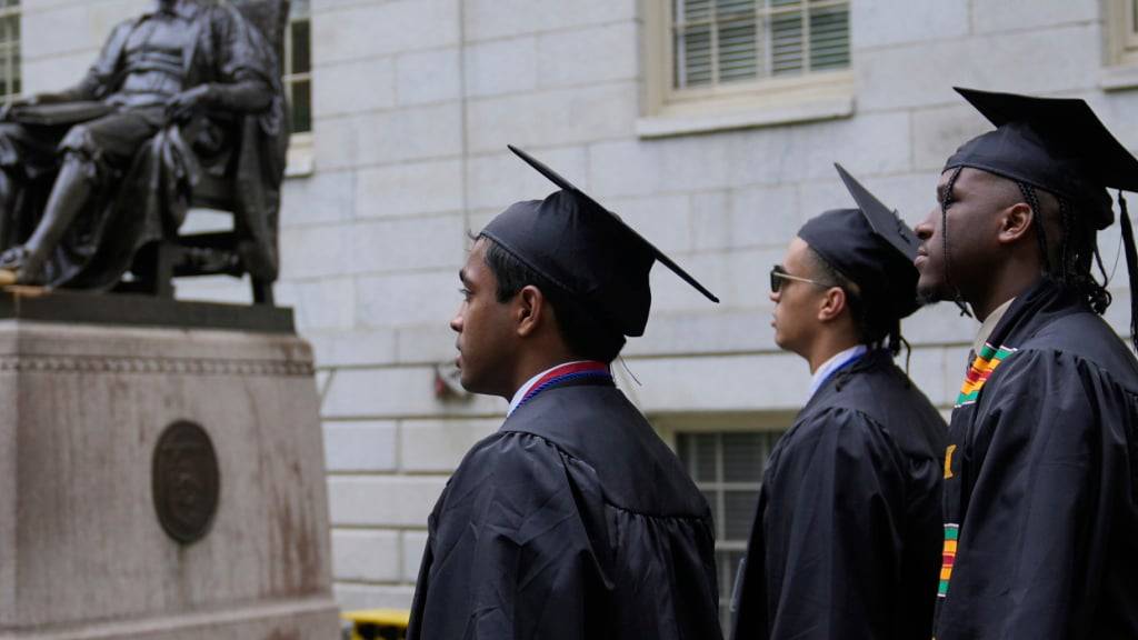 Studenten schreiten durch den Harvard Yard während der Feierlichkeiten zur Verleihung des akademischen Grades an der Harvard University. Foto: Charles Krupa/AP/dpa
