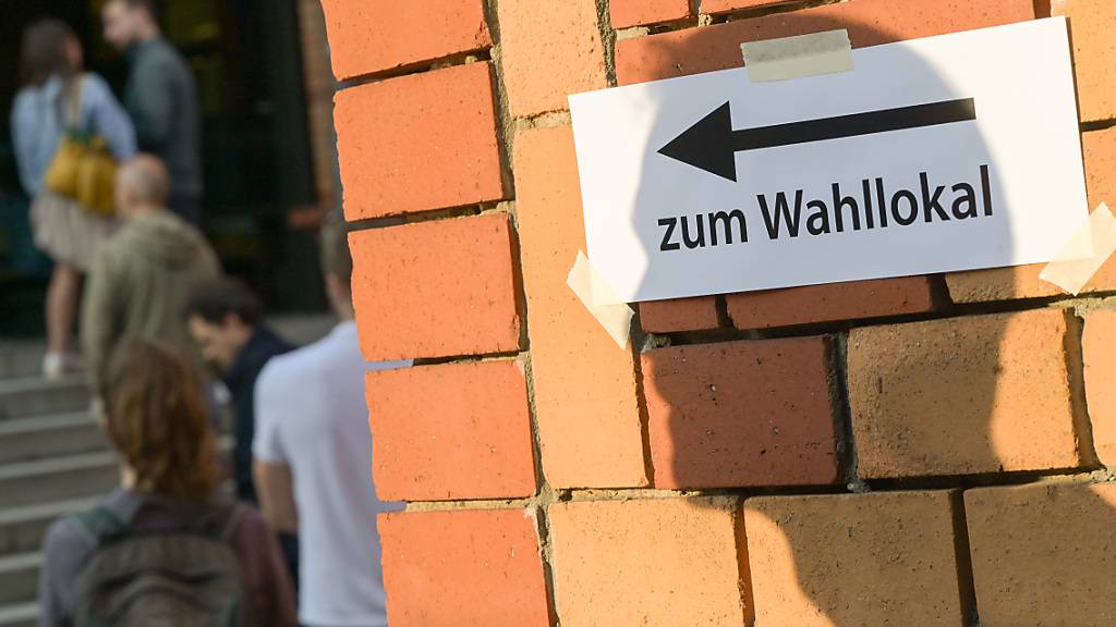 ARCHIV - Wählerinnen und Wähler stehen vor der Schließung der Wahllokale vor einem Wahllokal. Foto: Sebastian Gollnow/dpa