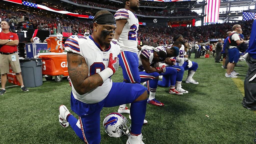 Einige NFL-Spieler knien während des Abspielens der US-Nationalhymne hin