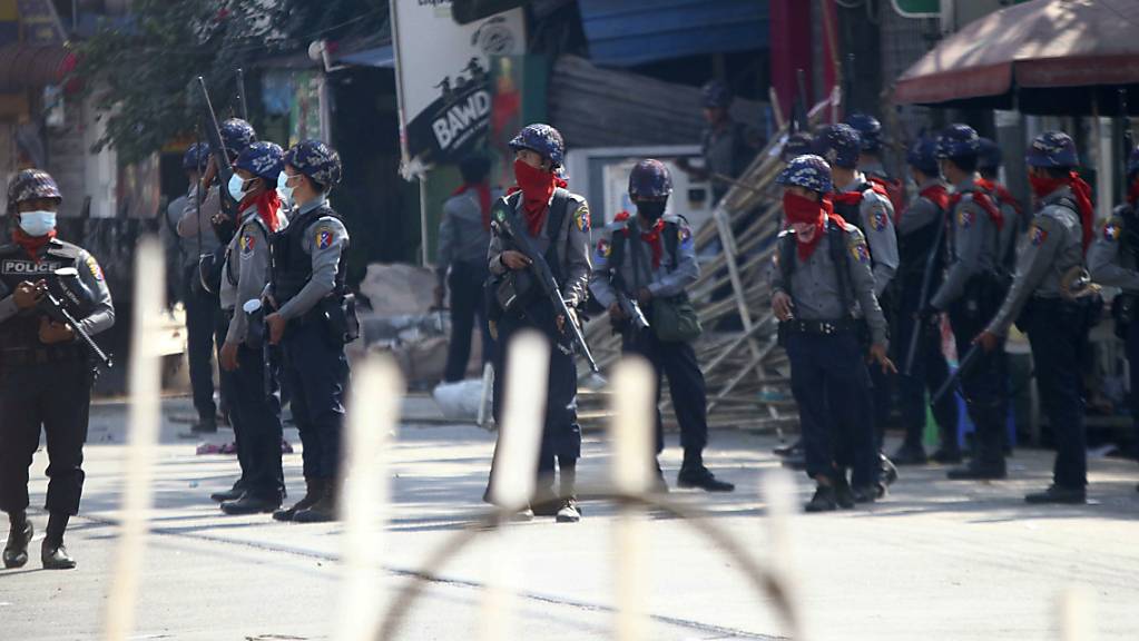 Bewaffnete Polizisten stehen auf einer Straße, um eine Demonstration gegen den Militärputsch zu verhindern. Foto: Str/AP/dpa