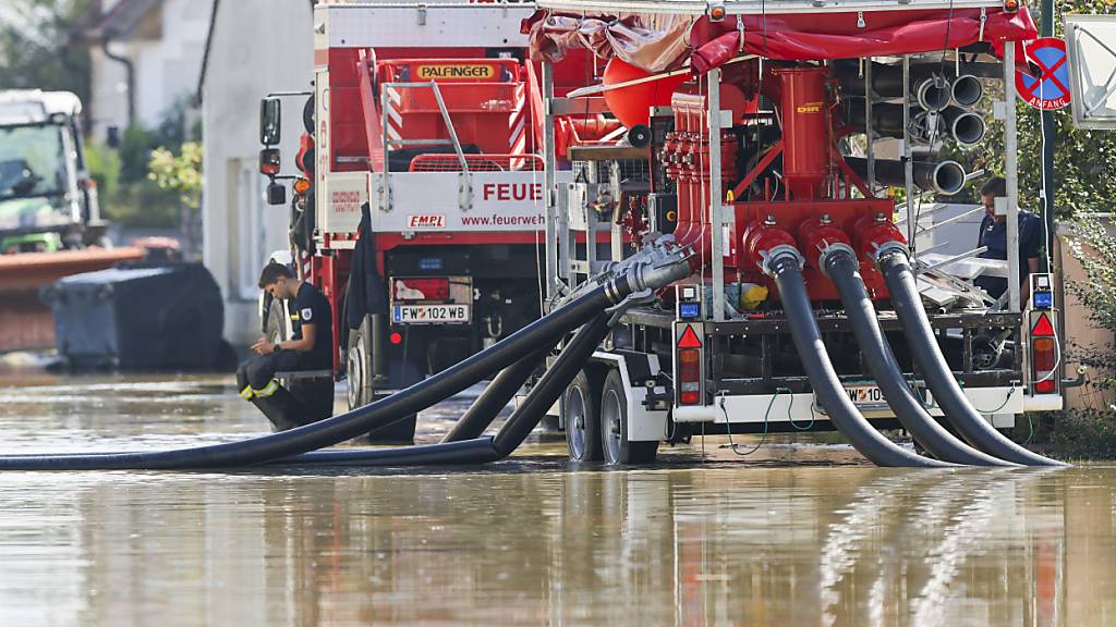 In dem österreichischen Dorf Kleinschönbichl setzt die Feuerwehr Pumpen ein, um Straßen und Felder vom Wasser zu befreien. Foto: Christoph Reichwein/dpa