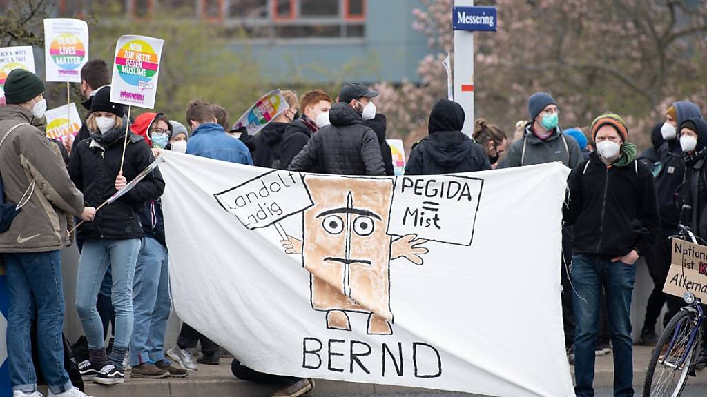 Demonstranten stehen mit einem Banner an einer Zufahrt vor dem Messegelände. In der Messe findet vom 10. bis 11. April 2021 der AfD-Bundesparteitag statt. Foto: Sebastian Kahnert/dpa-Zentralbild/dpa
