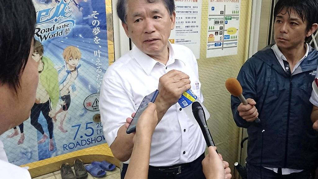 Hideaki Hatta (Mitte), Präsident der Kyoto Animation, spricht sichtlich geschockt mit Journalisten nach dem mutmasslichen Brandanschlag auf sein Zeichentrick-Filmstudio.