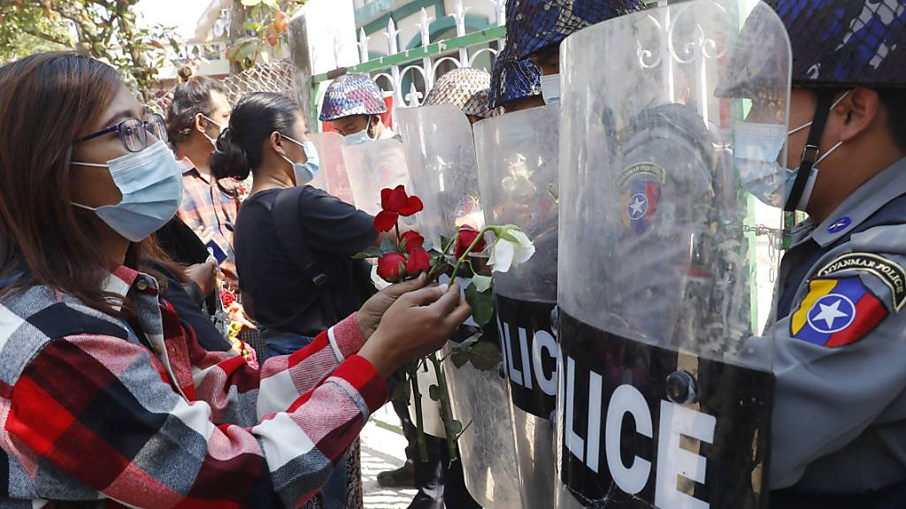 dpatopbilder - Demonstranten überreichen der Polizei Rosen, während vier festgenommene Aktivisten vor Gericht erscheinen. Hunderte von Studenten und Lehrern sind in Myanmar auf die Strasse gegangen, um zu fordern, dass das Militär die Macht an gewählte Politiker zurückgibt. Foto: Uncredited/AP/dpa