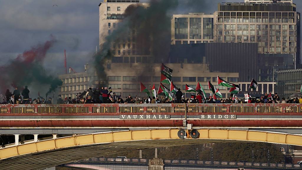 Demonstranten schwenken Fahnen und halten Fackeln während einer pro-palästinensischen Demonstration. Die Londoner Polizei hat ihre Bemühungen verstärkt, um sicherzustellen, dass ein pro-palästinensischer Marsch am Samstag friedlich bleibt, nachdem eine Woche lang politisch darüber gestritten wurde, ob die Demonstration an dem Wochenende stattfinden soll, an dem Großbritannien seiner Kriegstoten gedenkt. Foto: Alberto Pezzali/AP/dpa