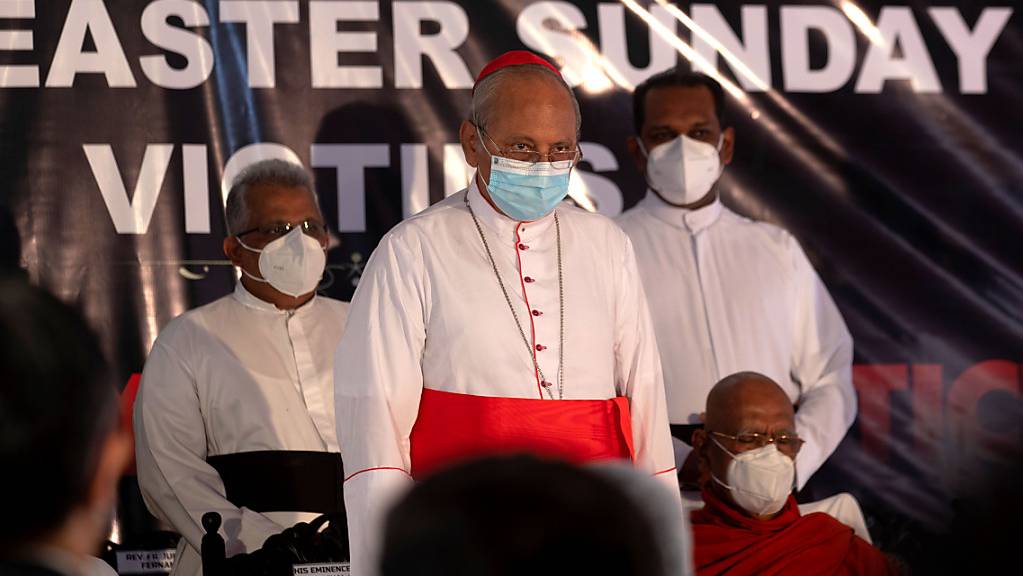 Kardinal Malcolm Ranjith (M), Erzbischof von Colombo, hält in der St. Anthony's Church während zwei Schweigeminuten in Gedenken an die Opfer der Anschläge vom Ostersonntag 2019 inne. Foto: Eranga Jayawardena/AP/dpa