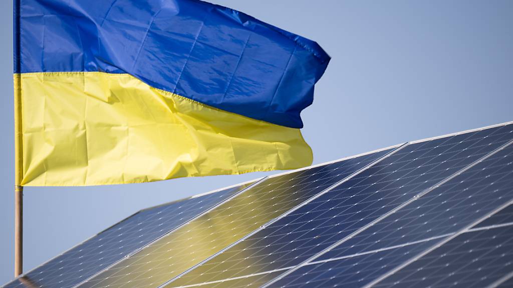 Eine Ukraine-Flagge weht über einer Solaranlage. Foto: Sebastian Gollnow/dpa