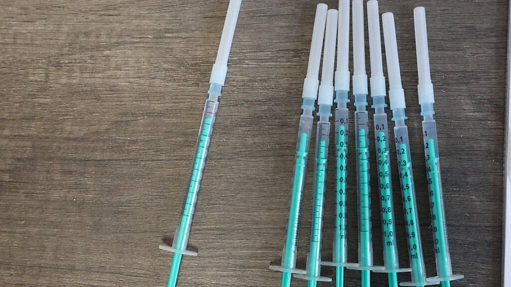 ARCHIV - Spritzen gefüllt mit dem Impfstoff von Biontech/Pfizer gegen Covid-19 liegen auf dem Tisch einer Hausarztpraxis. (Symbolbild) Foto: Bodo Schackow/dpa-Zentralbild/dpa