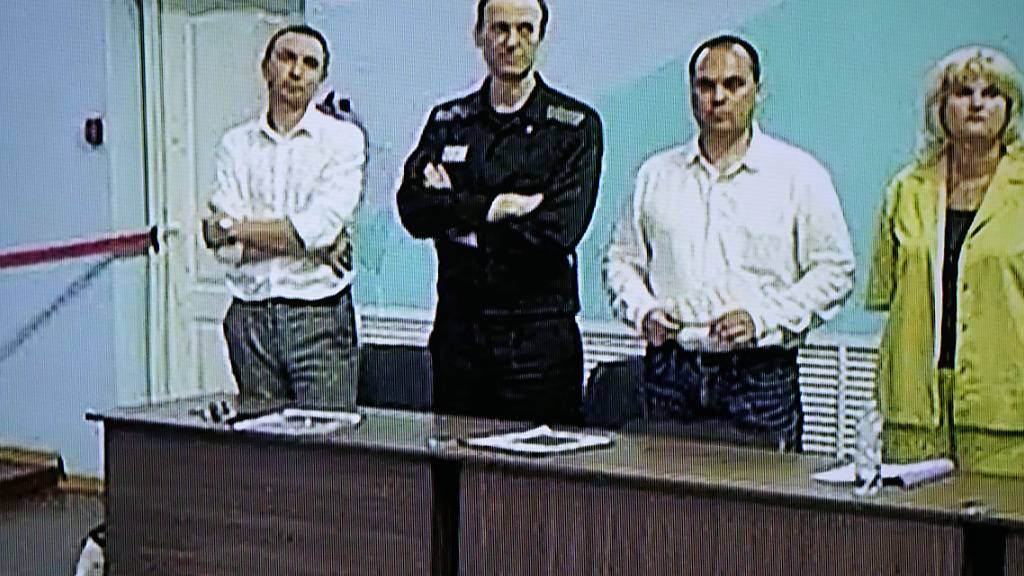 Alexej Nawalny (2.v.l), Oppositionspolitiker aus Russland, ist in einem von der russischen Strafvollzugsbehörde zur Verfügung gestellten Videolink auf einem Bildschirm zu sehen, während er bei einer Anhörung neben seinen Anwälten steht. Ein russisches Gericht hat den inhaftierten Kremlgegner am Freitag zu einer Haftstrafe von 19 Jahren in einem Straflager verurteilt. Foto: Alexander Zemlianichenko/AP/dpa