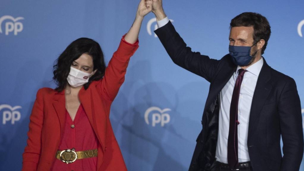 Isabel DÌaz Ayuso (l), Spitzenkandidatin der konservativen Volkspartei (PP), und Pablo Casado (r), Vorsitzender der Partei, feiern den Wahlsieg. Foto: Bernat Armangue/AP/dpa