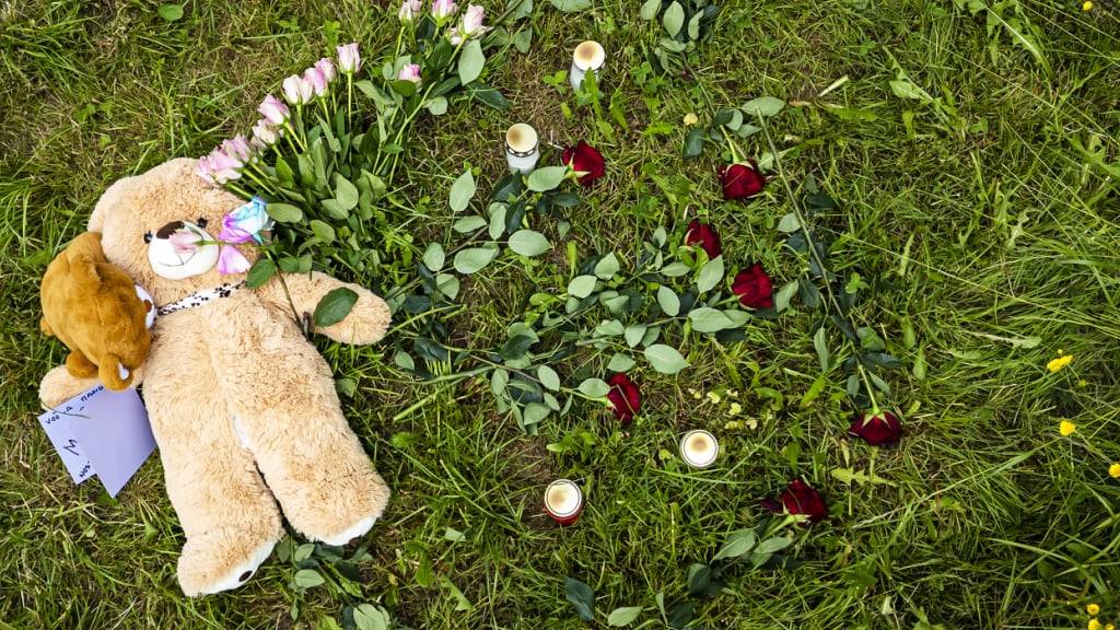 Auf einem Feld an einem Waldrand in der Nähe des Schützenhaus Berikon liegen Plüschtiere, Blumen und Kerzen.