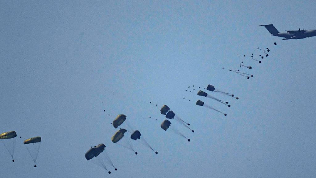 dpatopbilder - Ein Flugzeug wirft humanitäre Hilfe über dem nördlichen Gazastreifen ab, vom Süden Israels aus gesehen. Foto: Leo Correa/AP/dpa