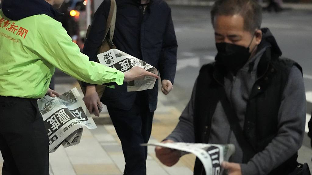 Menschen in Tokio lesen die Sonderausgabe einer Zeitung, die über die Erdbeben in Japan berichtet. Foto: Shuji Kajiyama/AP/dpa