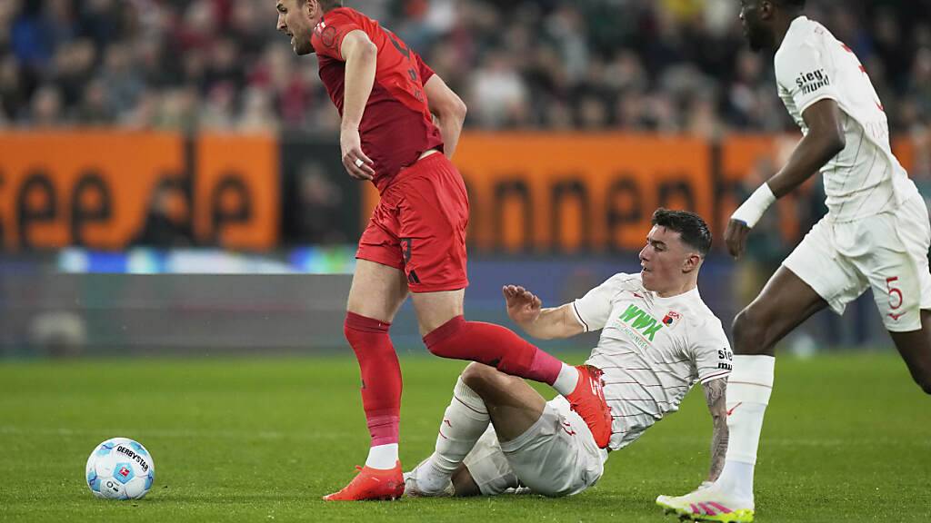 Mit fairen Mitteln nicht zu stoppen: Augsburgs Cédric Zesiger (m.) kommt gegen Harry Kane zu spät und muss am Ende nach zwei Gelben Karten frühzeitig vom Platz