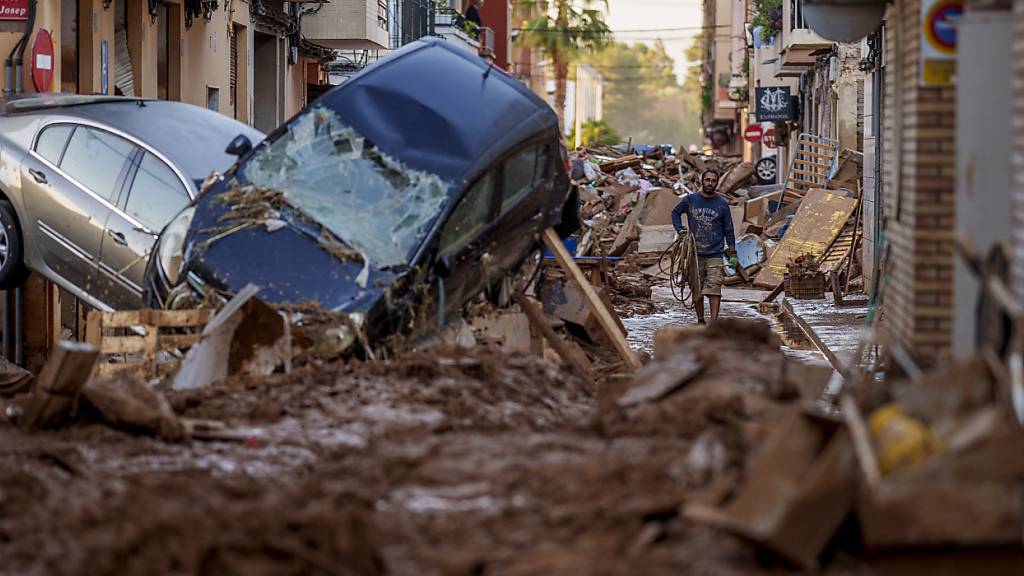 dpatopbilder - Ein Mann geht durch eine von Überschwemmungen betroffene Straße in Valencia. Foto: Manu Fernandez/AP/dpa