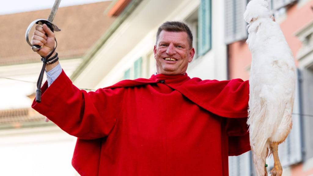 Reto Burri aus Kaltbach jubelt, nachdem er mit einem Hieb den Hals einer toten, am Kopf aufgehängten Gans an der Gansabhauet in Sursee durchtrennt hat.