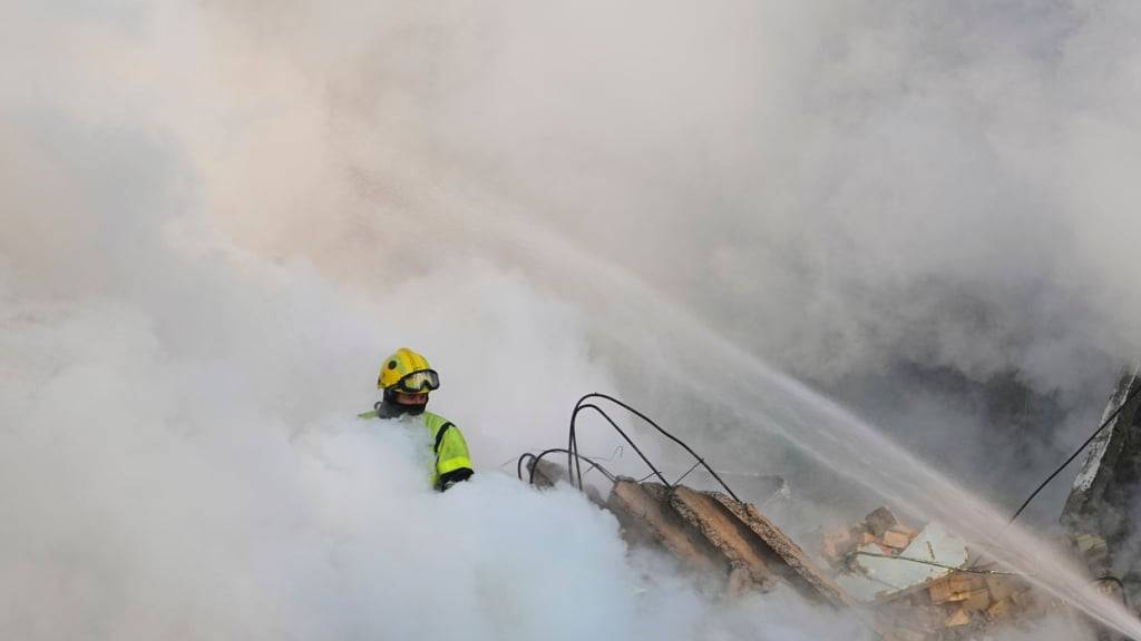 dpatopbilder - Feuerwehrleute löschen ein brennendes Wohnhaus nach einem russischen Angriff. Foto: Efrem Lukatsky/AP/dpa