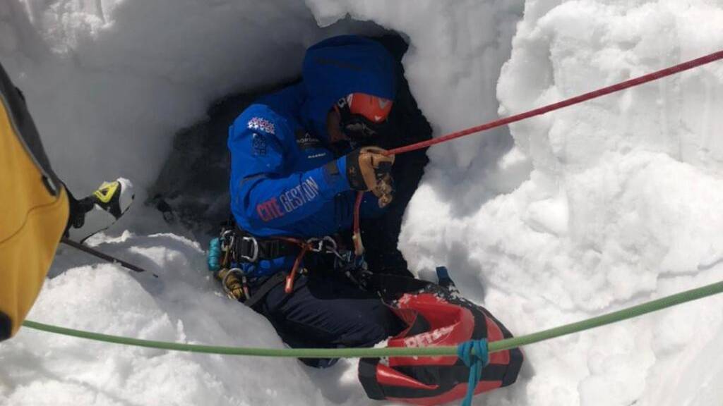 Ein Rettungsspezialist seilt sich zum verunfallten Skifahrer ab. Der Italiener brach durch die Schneedecke, fiel in den darunterliegenden Gletscherbach und wurde unter dem Schnee mehrere Meter talwärts gespült.