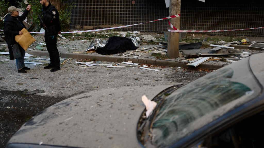 dpatopbilder - Ein Polizist spricht mit einem Anwohner neben den Leichen zweier Menschen, die bei einem nächtlichen russischen Angriff ums Leben gekommen sind. Foto: Francisco Seco/AP/dpa