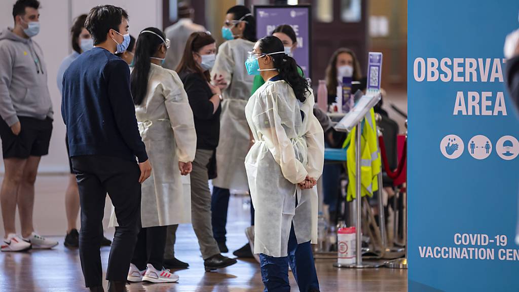 A health worker directs people into the 15-minute waiting area after receiving their vaccinations at the Royal Exhibition Building COVID19 Vaccination Hub in Melbourne, Thursday, September 2, 2021. Most of Victoria's tough coronavirus restrictions will remain in place until 70 per cent of eligible people have received at least one vaccine dose. (AAP Image/Daniel Pockett) NO ARCHIVING