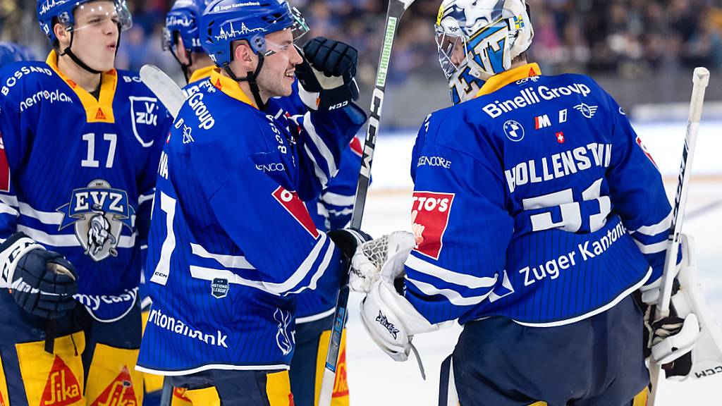 Die Zuger feiern mit ihrem Goalie und Matchwinner Luca Hollenstein