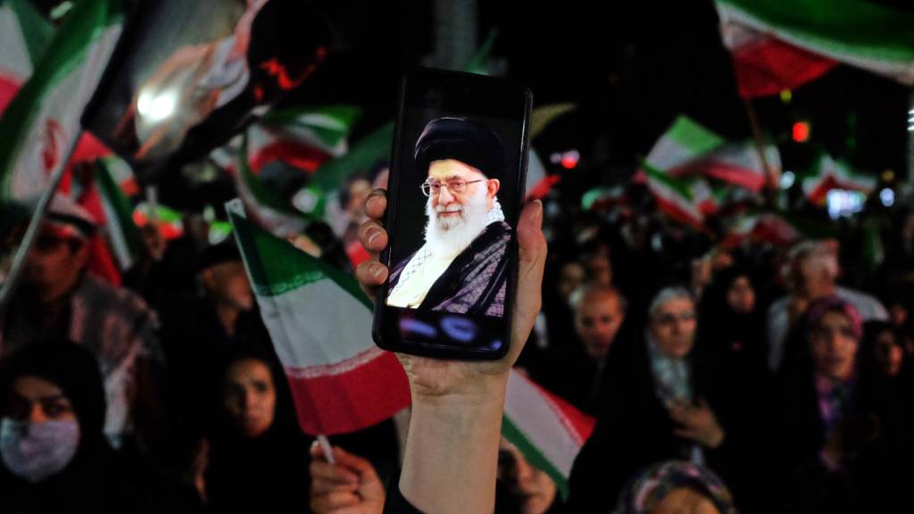ARCHIV - Ein regierungsfreundlicher Demonstrant hält während einer Kundgebung ein Handy hoch, auf dessen Bildschirm ein Bild des verstorbenen iranischen Obersten Führers Ajatollah Ali Chamenei zu sehen ist. Foto: Vahid Salemi/AP/dpa (Archivbild)