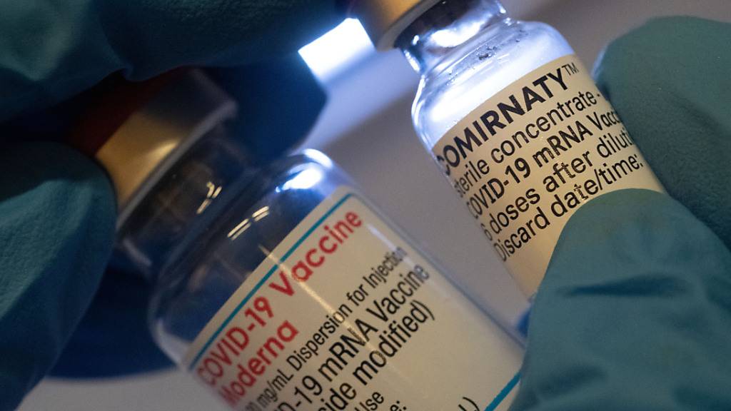 Eine medizinische Fachkraft hält Ampullen mit den Impfstoffen der Hersteller Moderna (l) und Biontech. Foto: Stefan Puchner/dpa