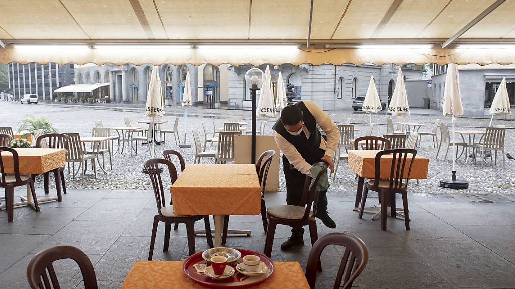 In der Schweiz werden weniger als hundert neue Corona-Fälle pro Tag gemeldet. Bei der Wiederöffnung von Cafés und Restaurants empfiehlt das Bundesamt für Gesundheit, weiterhin die Hygienemassnahmen einzuhalten. Im Bild desinfiziert ein Kellner einen Stuhl in einem Restaurant.