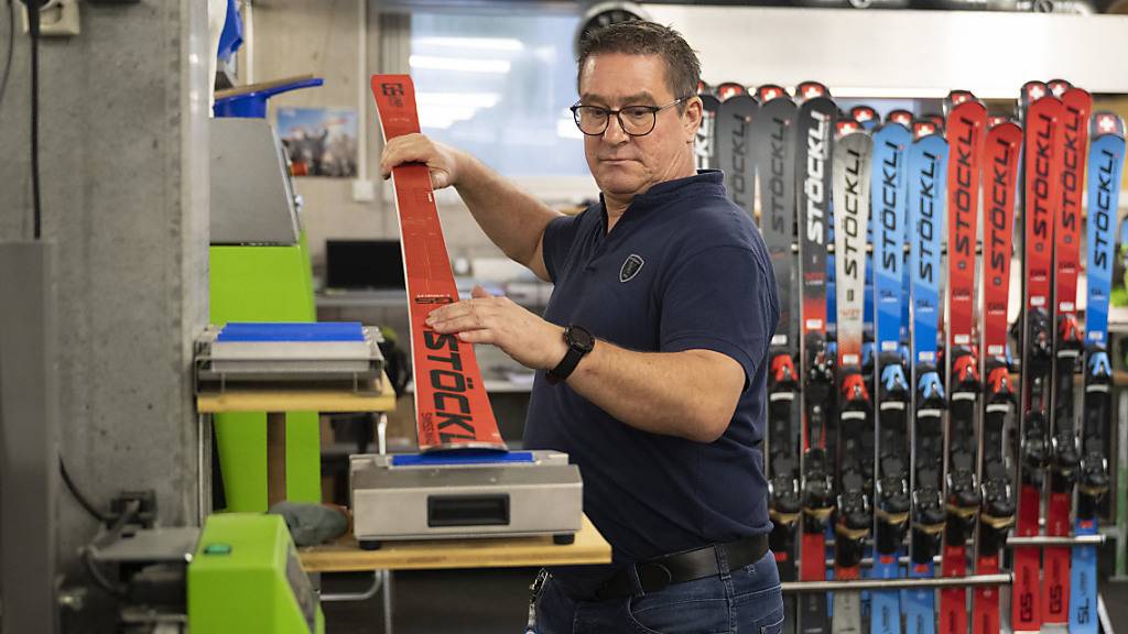 Ein Mitarbeiter bringt Wachs auf einem Skibelag auf
