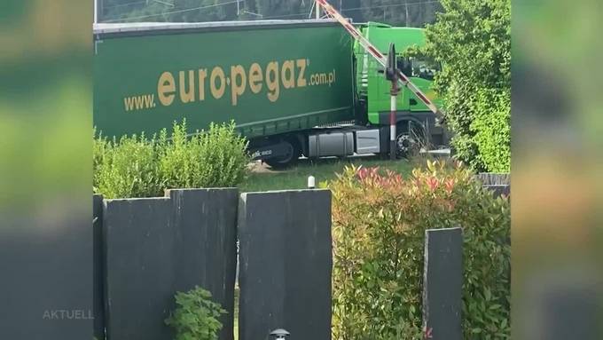Lastwagenchauffeur verfängt sich an Barriere auf Bahnübergang