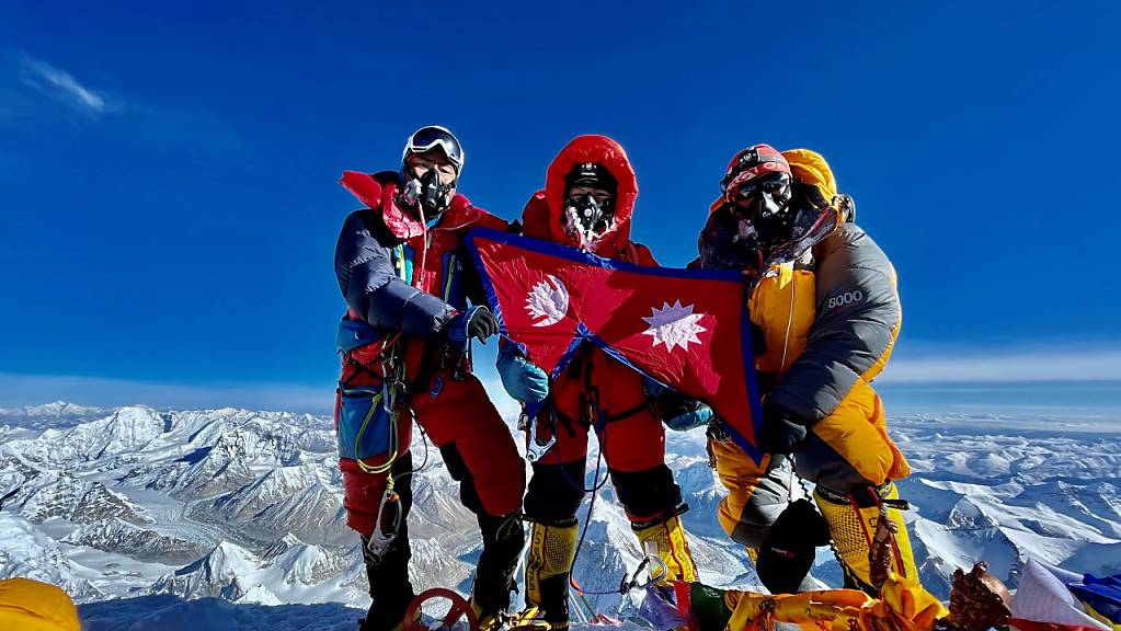 Nima Lhamu Sherpa (M) steht mit ihren Brüdern auf dem Gipfel des Mount Everest. 