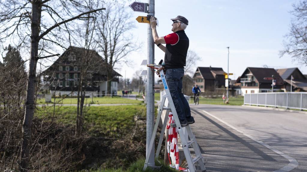Beny Walker von der Infrastruktur der Zuger Wanderwege putzt Wanderwegtafeln. (Symbolbild)