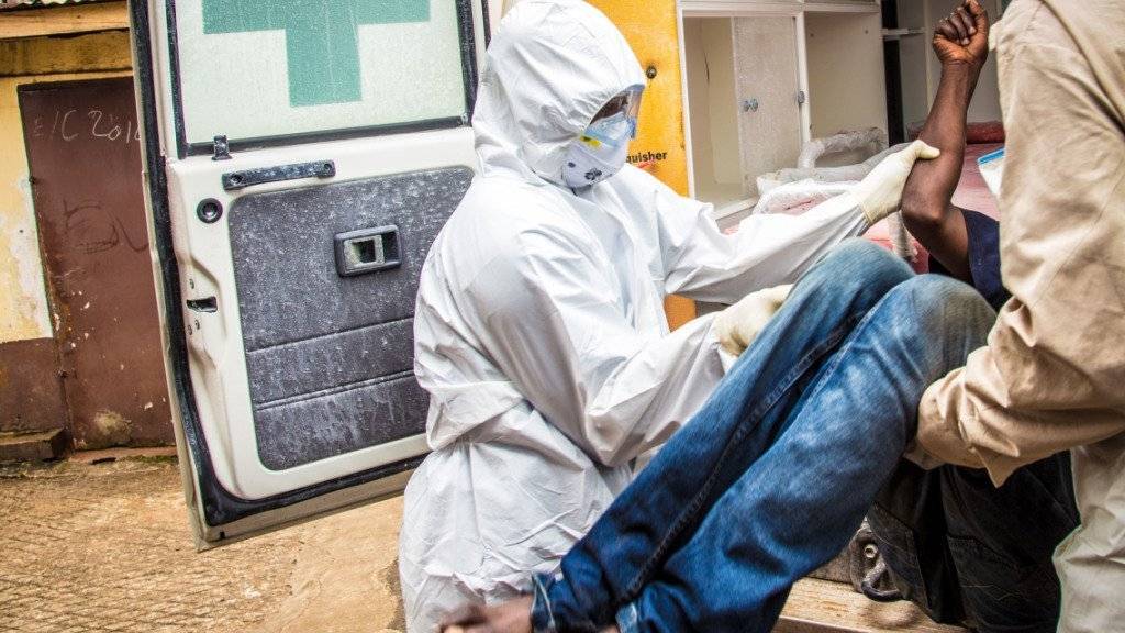 Mitarbeiter der Gesundheitsdienste tragen zum Höhepunkt der Ebola-Epidemie einen Ebola-Kranken in eine Ambulanz. In Sierra Leone ist erneut ein Ebola-Fall aufgetaucht. (Archiv)