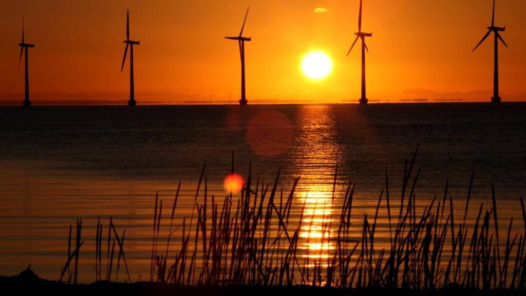 ARCHIV - Die Sonne geht hinter Windrädern in Kopenhagen auf. Foto: Steffen Trumpf/dpa