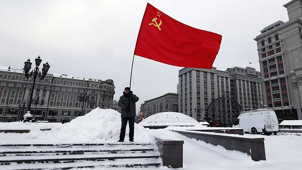 Ein Kommunist schwenkt die Sowjetunion-Flagge auf dem Roten Platz in Moskau (Archiv)